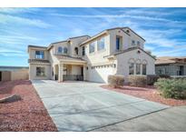 Elegant two-story home featuring a tile roof, spacious driveway, and desert landscaping, bathed in bright sunlight at 15033 W Statler St, Surprise, AZ 85374