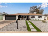 Charming single-story home featuring a manicured front yard with stylish gravel and an attached two-car garage at 2502 W Freeway Ln, Phoenix, AZ 85021