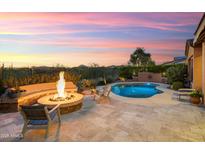 Inviting backyard oasis with a stone fire pit and pristine pool, perfect for outdoor entertaining and relaxation at 30110 N 129Th Gln, Peoria, AZ 85383