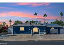 Charming single-story home with solar panels and desert landscaping under a colorful sky at 3224 E Sweetwater Ave, Phoenix, AZ 85032