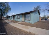 Charming blue apartment building with decorative bars, rock landscaping, and a well-maintained walkway at 3646 N 67Th Ave # 12, Phoenix, AZ 85033