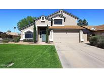 Charming two-story home with a well-manicured lawn, two-car garage, and a beautifully designed front door at 4338 E Towne Ln, Gilbert, AZ 85234