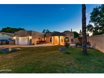 Inviting home with lush lawn, fountain, and a two-car garage showcasing its charming curb appeal at 866 N Forest --, Mesa, AZ 85203