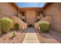 Inviting condo exterior with well-maintained landscaping and dual staircase access at 9735 N 94Th Pl # 110, Scottsdale, AZ 85258