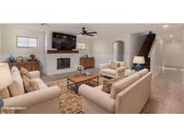 Cozy living room with a fireplace, wainscoting, tile floors, and neutral decor at 12056 W Melinda Ln, Sun City, AZ 85373