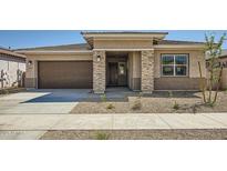 Inviting single-story home showcasing a neutral palette, stone accents, and a well-maintained front yard at 15005 W Gray Fox Trl, Surprise, AZ 85387