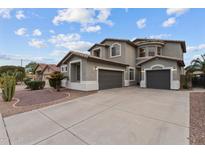 Two-story home with a three-car garage and a well-manicured desert landscape at 16533 W Carmen Dr, Surprise, AZ 85388