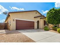 Charming home exterior with a spacious driveway and low-maintenance desert landscaping at 16771 W Adams St, Goodyear, AZ 85338