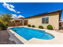 Inviting backyard pool with lush landscaping and stucco home exterior at 16771 W Adams St, Goodyear, AZ 85338