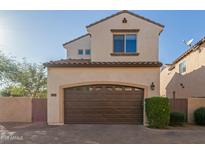 Charming two-story home with a brown garage door and tiled roof at 2004 E Heartwood Ln, Phoenix, AZ 85022