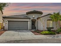 Inviting single-story home with a barrel tile roof, gray two-car garage, and charming round tower entry at 2169 N 212Th Ln, Buckeye, AZ 85396