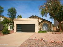 Charming home featuring a black garage door and desert landscaping at 3948 W Butler St, Chandler, AZ 85226