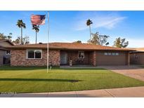 Charming brick home with manicured front lawn, palm trees, and an American flag waving proudly at 4729 E Dolphin Ave, Mesa, AZ 85206