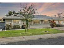 Charming single-story home featuring a well-manicured lawn, solar panels, and lovely curb appeal at 4938 W Tuckey Ln, Glendale, AZ 85301