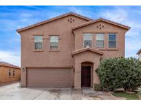 Two-story home featuring a two-car garage, neutral colored stucco, and a covered front porch at 6925 W Maldonado Rd, Laveen, AZ 85339
