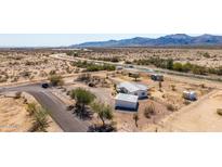 Expansive property featuring a single-Gathering home and various structures in a scenic desert setting, highlighting potential and privacy at 13802 N 186Th Ave, Surprise, AZ 85388