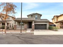 Charming two-story home featuring a two-car garage, covered porch, and desert landscaping at 15365 W Valentine St, Surprise, AZ 85379