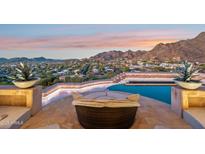 Relaxing lounge seating area next to a pristine infinity pool overlooking mountain and city views at 1721 E Hatcher Dr, Phoenix, AZ 85020
