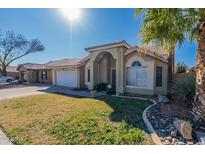 Charming single-story home featuring an arched entryway, a two-car garage, and desert landscaping at 17402 N 45Th St, Phoenix, AZ 85032