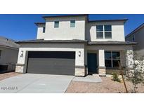 Two-story home featuring a gray garage door and neutral stucco exterior with stone accents at 17648 W Sanna St, Waddell, AZ 85355