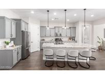 Modern kitchen featuring gray cabinets, granite countertops, stainless steel appliances, and an expansive island with bar seating at 1980 E Horseshoe Dr, Chandler, AZ 85249