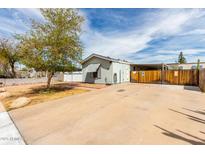 Cozy single-story home featuring a spacious driveway and a charming, well-maintained front yard with a mature tree at 2145 N Silverton St, Mesa, AZ 85203