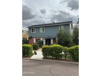 Charming two-story home with brick and blue siding, featuring well-maintained landscaping and a walkway to the front door at 1333 E Flower St # Rear, Phoenix, AZ 85014