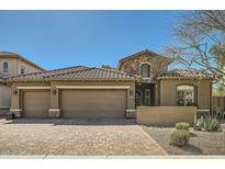 Charming home showcasing a three-car garage, stone accents and desert landscaping at 2059 W Whisper Rock Trl, Phoenix, AZ 85085