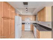 Traditional eat-in kitchen features neutral cabinets, appliances and countertop with recessed lighting at 8155 E Roosevelt St # 204, Scottsdale, AZ 85257