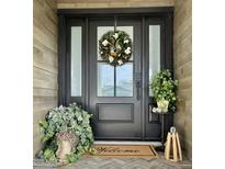 Stylish black front door framed by sidelights and adorned with a festive wreath for a welcoming entrance at 8238 E San Miguel Ave, Scottsdale, AZ 85250