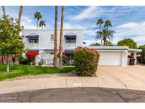 Charming two-story home with a well-manicured lawn and beautiful mature trees creating great curb appeal at 8438 E Stella Ln, Scottsdale, AZ 85250