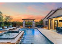Inviting backyard pool with spa, lounge chairs, covered dining, and beautiful sunset views at 9929 E South Bend Dr, Scottsdale, AZ 85255