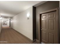 Condo hallway featuring neutral paint, carpet, and a door with decorative trim, creating a welcoming entrance at 14000 N 94Th St # 3094, Scottsdale, AZ 85260