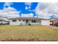 Charming single-story home featuring a welcoming porch, a well-maintained lawn, and an attached garage with an open carport at 1840 E Jarvis Ave, Mesa, AZ 85204