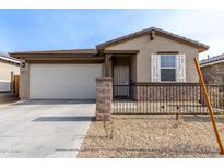 Charming single-story home features a low-maintenance gravel yard and a two-car garage at 1971 S 241St Dr, Buckeye, AZ 85326