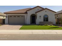 Charming single-story home features a tile roof, arched entry, and well-manicured artificial lawn at 2887 W Chevelon Dr, Queen Creek, AZ 85144