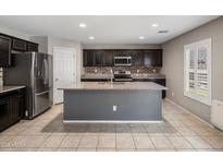 A well-lit kitchen featuring stainless steel appliances, granite countertops, tile backsplash, and a spacious center island at 2929 E Binner Dr, Chandler, AZ 85225