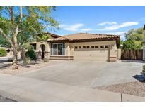 Charming single-story home with a tile roof, tan stucco, and a spacious two-car garage at 2994 E Sports Ct, Gilbert, AZ 85298