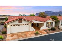 Inviting single-story home with a red tile roof, a two-car garage, and charming desert landscaping at 3301 S Goldfield Rd # 3005, Apache Junction, AZ 85119