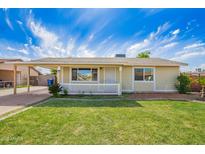 Charming single-story home with a well-manicured lawn and a white picket fence at 332 N 25Th St, Mesa, AZ 85213