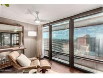 Bright living room with a chair and floor-to-ceiling windows showcasing expansive cityscape views at 4808 N 24Th St # 1427, Phoenix, AZ 85016