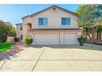 Inviting two-story home features a three-car garage and a well-maintained, charming front yard at 5291 W Angela Dr, Glendale, AZ 85308