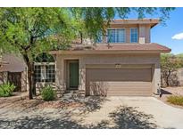 Charming two-story home featuring a well-maintained front yard, a two-car garage, and a welcoming entrance at 7650 E Williams Dr # 1038, Scottsdale, AZ 85255