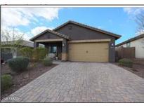 Charming single-story home featuring a brick driveway, desert landscaping, and a two-car garage at 8490 S 165Th Dr, Goodyear, AZ 85338