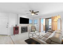 Bright living room featuring a tile fireplace, ceiling fan, sliding glass doors to balcony, and comfortable seating at 14645 N Fountain Hills N Blvd # 215, Fountain Hills, AZ 85268