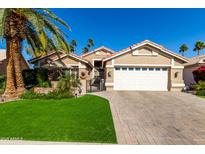 Charming single-story home featuring a well-manicured lawn, tiled roof, and a spacious two-car garage at 15460 W Merrell St, Goodyear, AZ 85395