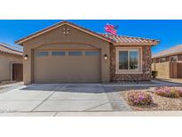 Charming single-Gathering home featuring a two-car garage and stone accents with easy to maintain desert landscaping at 16573 W Alameda Rd, Surprise, AZ 85387