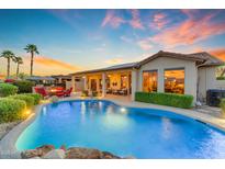 Stunning backyard pool with rock features, a covered patio, and an outdoor fire pit at 3183 N 159Th N Ave, Goodyear, AZ 85395