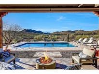 A luxurious outdoor living space with a pool, fire pit, and stunning mountain views for relaxation and entertainment at 36190 N Creek View Ln, Cave Creek, AZ 85331