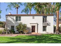 Charming two-story home with red tile roof, stucco walls, and manicured lawn featuring palm trees at 374 E Verde Ln, Phoenix, AZ 85012